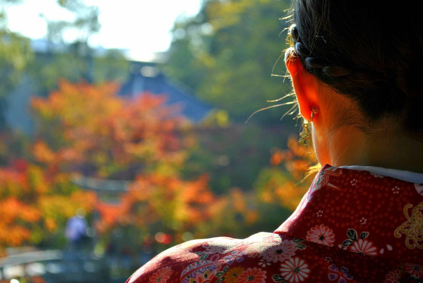 女性のうなじと紅葉の写真